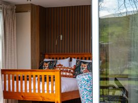 A bedroom with a wooden bed and decorative pillows at The Fox Den in Nantmel near Rhayader