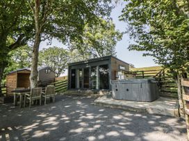 An outdoor area with a hot tub and seating at The Fox Den in Nantmel near Rhayader