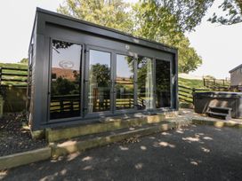 A building with large doors and a hot tub at The Fox Den Nantmel near Rhayader