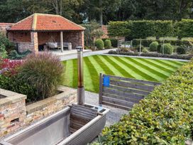 A garden with a gazebo and lawn at Flittermouse Barn Hornsea