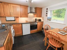 A kitchen with wooden cabinets and appliances at Kiln How Threlkeld