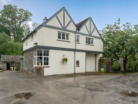 An exterior view of a house with stone walls and windows at Home Farmhouse at the Graythwaite Estate near Hawkshead