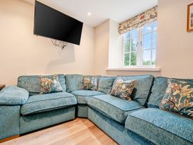A living room with a sofa and television at Home Farmhouse at the Graythwaite Estate near Hawkshead