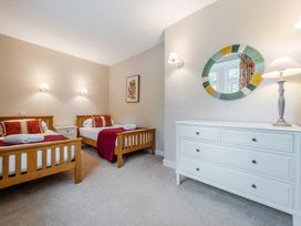 A bedroom with two beds and a dresser at Home Farmhouse at the Graythwaite Estate near Hawkshead