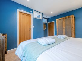 A bedroom with a bed and wardrobe at Home Farmhouse at the Graythwaite Estate near Hawkshead