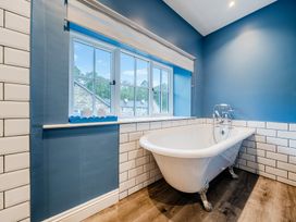 A bathroom with a bathtub and a window at Home Farmhouse at the Graythwaite Estate near Hawkshead