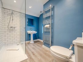 A bathroom with a shower, sink, toilet and towel rail at Home Farmhouse at the Graythwaite Estate near Hawkshead