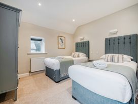 A bedroom with two beds and a window at Home Farmhouse at the Graythwaite Estate near Hawkshead