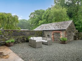 An outdoor seating area with furniture and a stone building at Home Farmhouse at the Graythwaite Estate near Hawkshead