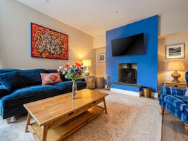 A living room with a sofa, coffee table, and fireplace at Home Farmhouse at the Graythwaite Estate near Hawkshead