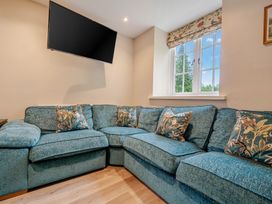 A living room with a sofa and television at Home Farmhouse at the Graythwaite Estate near Hawkshead