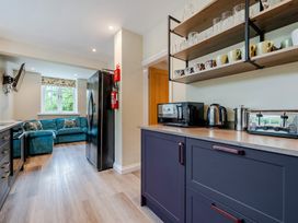 A kitchen with appliances and a sofa at Home Farmhouse at the Graythwaite Estate near Hawkshead