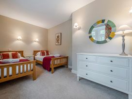 A bedroom with two beds and a dresser at Home Farmhouse at the Graythwaite Estate near Hawkshead