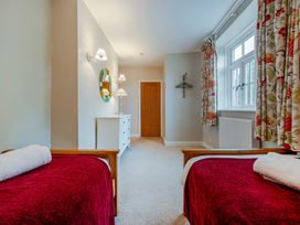 A bedroom with two beds and a dresser at Home Farmhouse at the Graythwaite Estate near Hawkshead