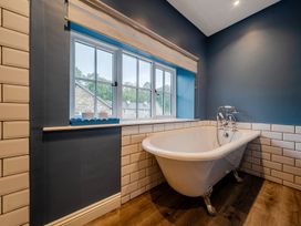 A bathroom with a bathtub and window at Home Farmhouse at the Graythwaite Estate near Hawkshead