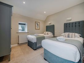 A bedroom with two single beds and a wardrobe at Home Farmhouse at the Graythwaite Estate near Hawkshead
