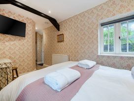 A bedroom with a bed and television at Home Farmhouse at the Graythwaite Estate near Hawkshead