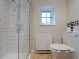 A bathroom featuring a shower, toilet, and window at Home Farmhouse at the Graythwaite Estate near Hawkshead