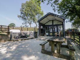 An outdoor area with a hot tub and picnic table at Woodland Escape in Rhayader