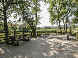 An outdoor seating area with a picnic table and trees at Woodland Escape in Rhayader