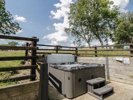 A hot tub with steps in a fenced outdoor area at Woodland Escape Rhayader