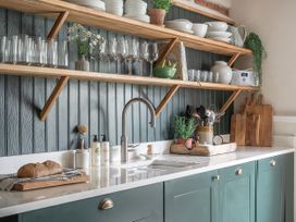 A kitchen with shelves containing glasses and utensils at Reybridge House in Lacock
