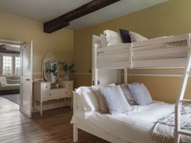 A bedroom with a bunk bed and a single bed at Reybridge House in Lacock