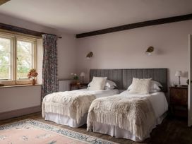 A bedroom with two beds and a window at Reybridge House in Lacock