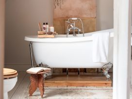 A bathroom with a bathtub and accessories at Reybridge House in Lacock