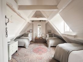 A bedroom with three beds and a mirror at Reybridge House in Lacock