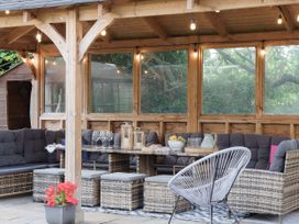 An outdoor seating area with a table and chairs at Reybridge House, Lacock