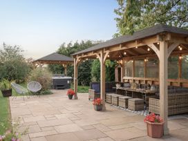 An outdoor patio with a gazebo and hot tub at Reybridge House in Lacock