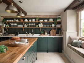 A kitchen with a large island and open shelves at Reybridge House in Lacock
