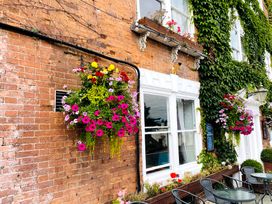 A wall with flower baskets and windows at The Escape Malvern