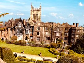 A hotel building with a garden and tower at Abbey Hotel in Malvern