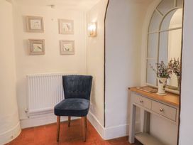A hallway with a chair, table, and photographs at Garden View in Wellington