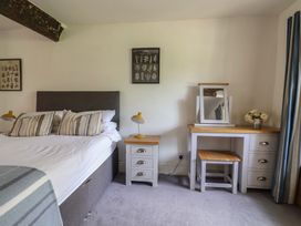 A bedroom with a bed, side table, dressing table and a mirror at Garden View, Wellington