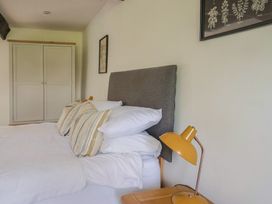 A bedroom with a bed, pillows, wardrobe, and lamp at Garden View in Wellington