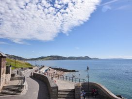 A beach view with a walking path and people at Garden View in Wellington