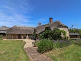 A house with a thatched roof and garden at Garden View in Wellington