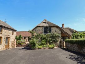 A thatched cottage with stone walls and a garden at Garden View in Wellington