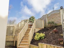 A garden with wooden stairs and a fence at Summer Rose in Craster