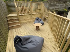 A garden deck with seating and table at Summer Rose in Craster