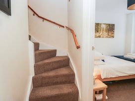 A staircase leading to a bedroom with a bed and lamp at Walkers Retreat in Keswick