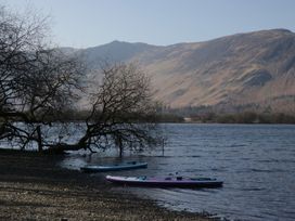 A lake with kayaks and mountains in the background at Walkers Retreat in Keswick