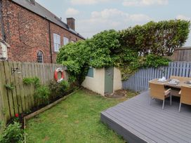 A garden with a deck and furniture at Over Esk in Whitby