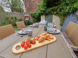 An outdoor dining area with a table set for breakfast at Over Esk Whitby