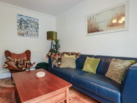A living room with a sofa and coffee table at Trevethen Cottage in Crantock
