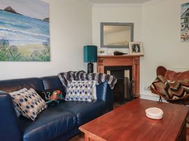 A living room with a sofa and coffee table at Trevethen Cottage in Crantock