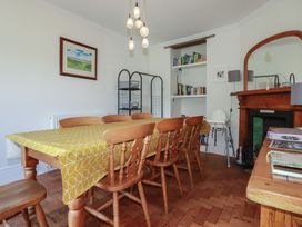 A dining room with a table and chairs at Trevethen Cottage in Crantock